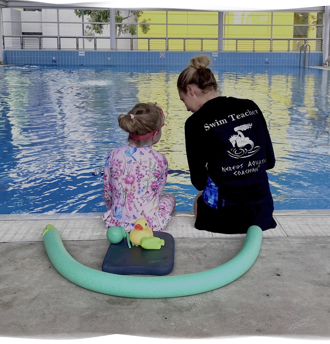 Nereids Swimming teacher guiding a nervous child poolside