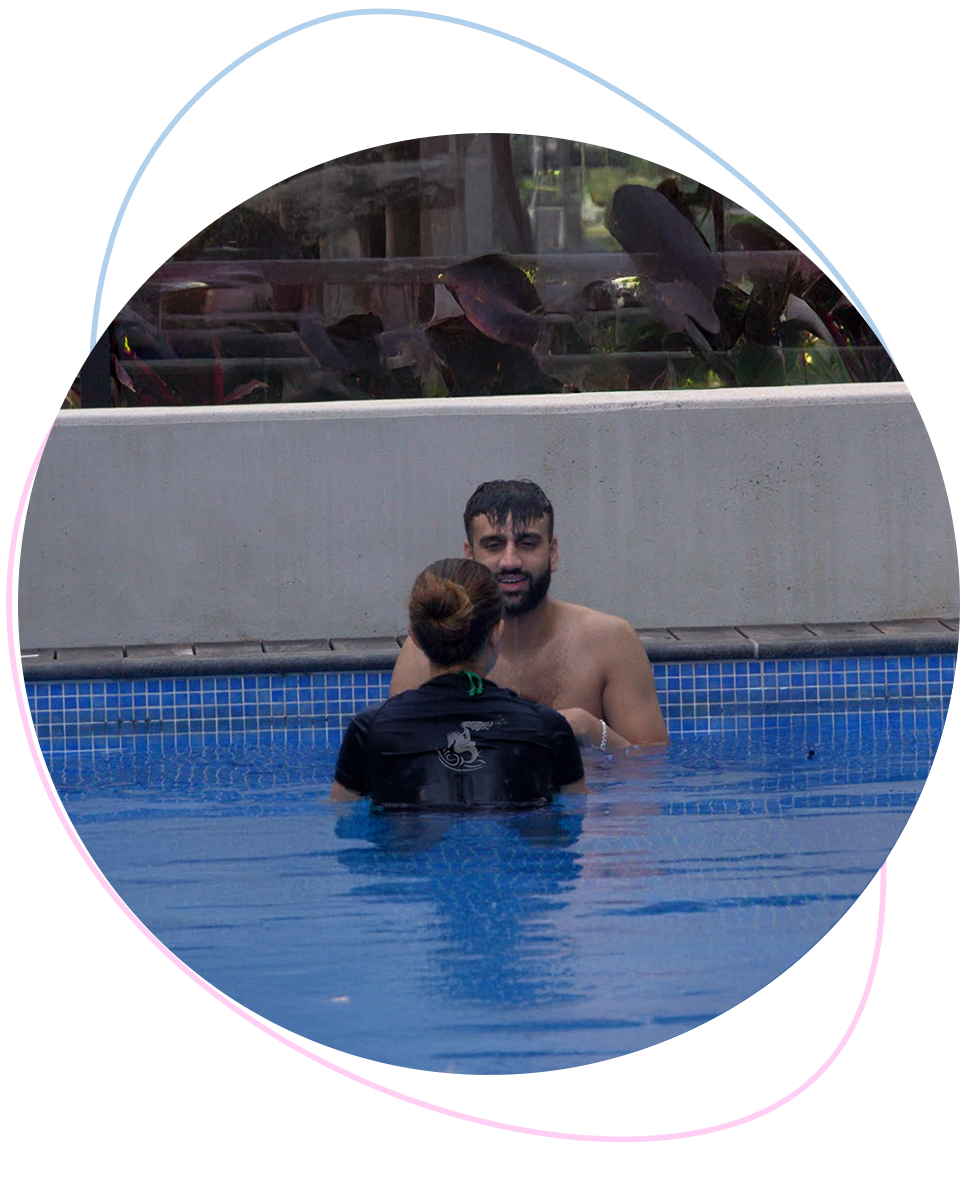 Happy adult swim student smiling after submerging under water with Nereids teacher offering encouragement