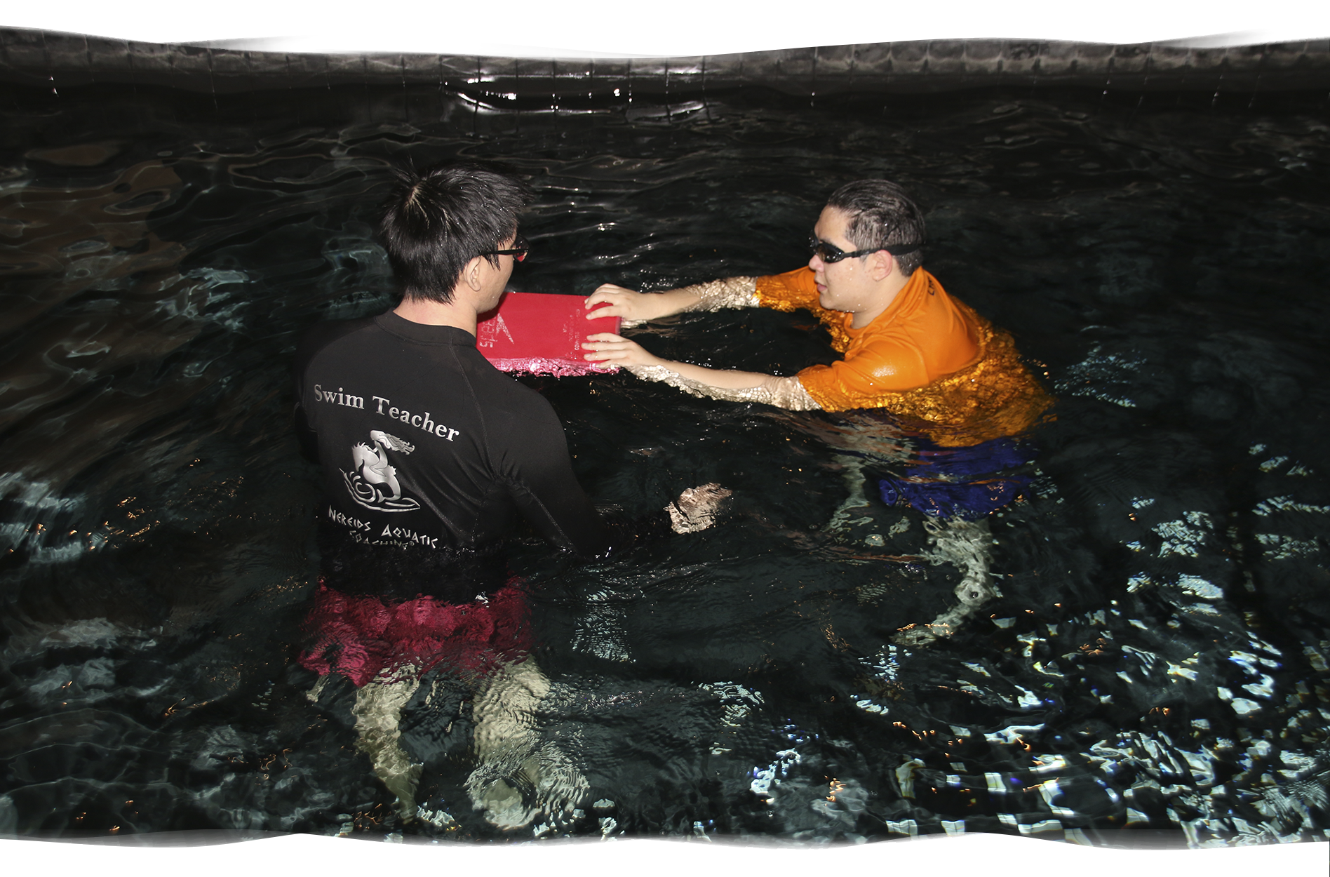 Nereids swim teacher giving final instructions to adult student before starting freestyle kick with kickboard