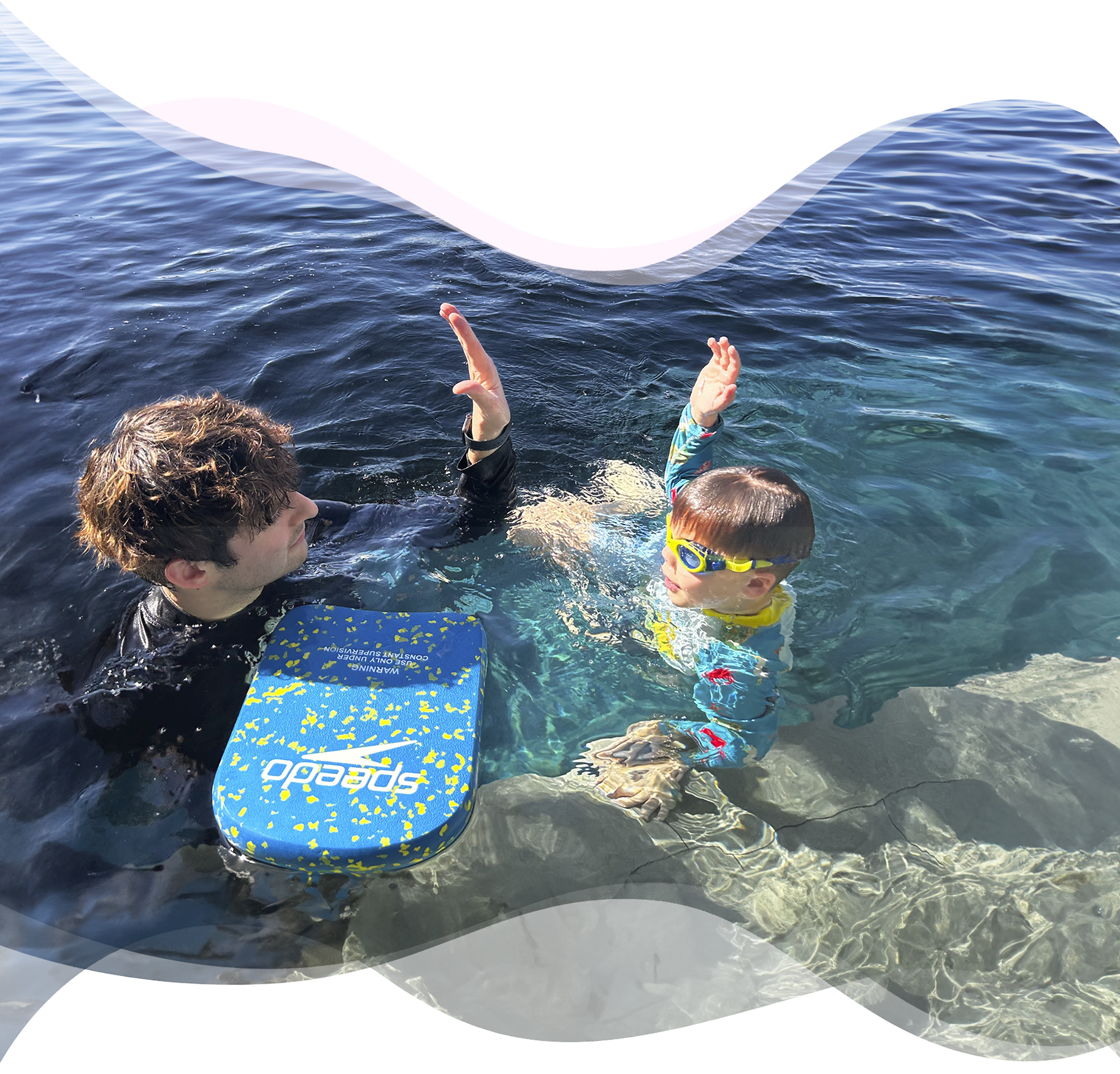 Nereids swim teacher and student high-fiving at the end of a lesson, celebrating progress and confidence in the water.