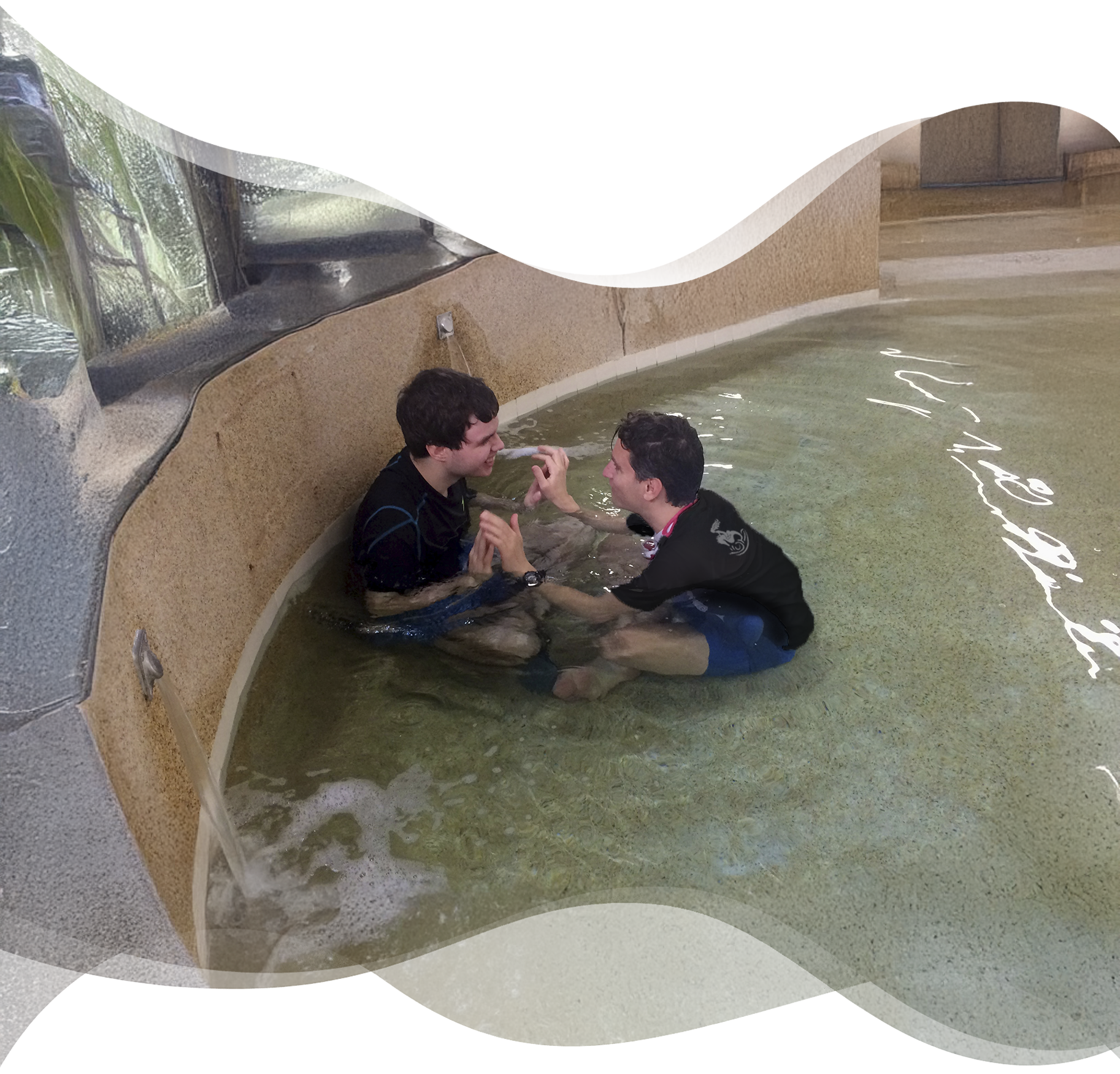 Student with autism joyfully interacting and laughing with his swim teacher in a shallow pool area during a Nereids swim session.