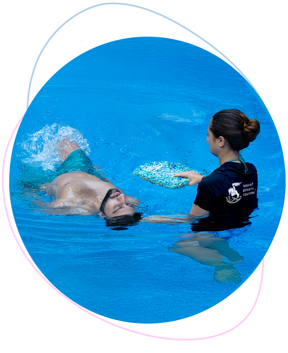 Adult student practising floating during a private confidence-building swimming lesson with a caring Nereids swim teacher.