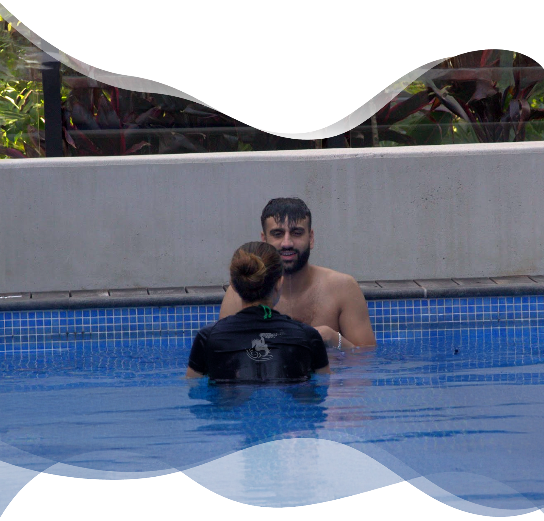 Adult student smiling joyfully at Nereids swim teacher after successfully submerging head in water