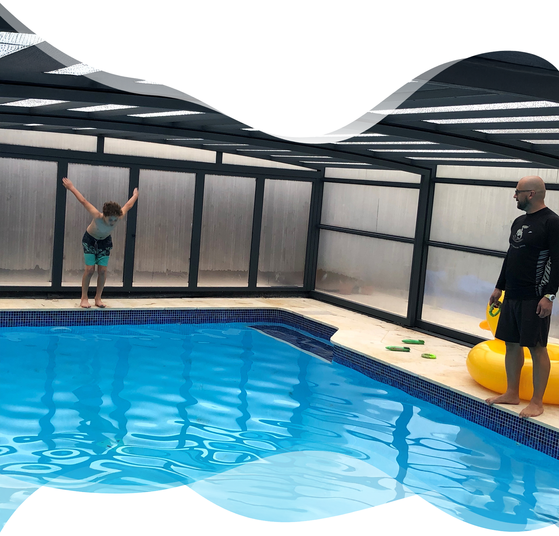 Young boy prepares to jump into the pool as his Nereids swim teacher focuses on his posture, building confidence and water safety skills.
