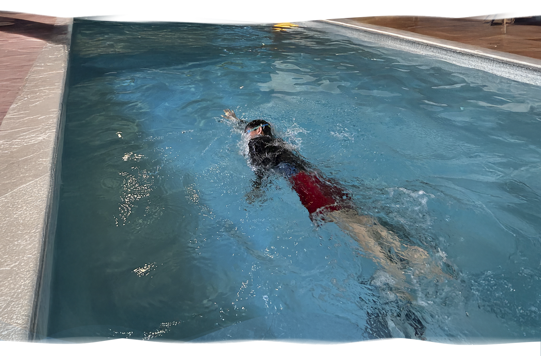 Adult swimming freestyle in apartment pool, representing the journey from struggle to refinement