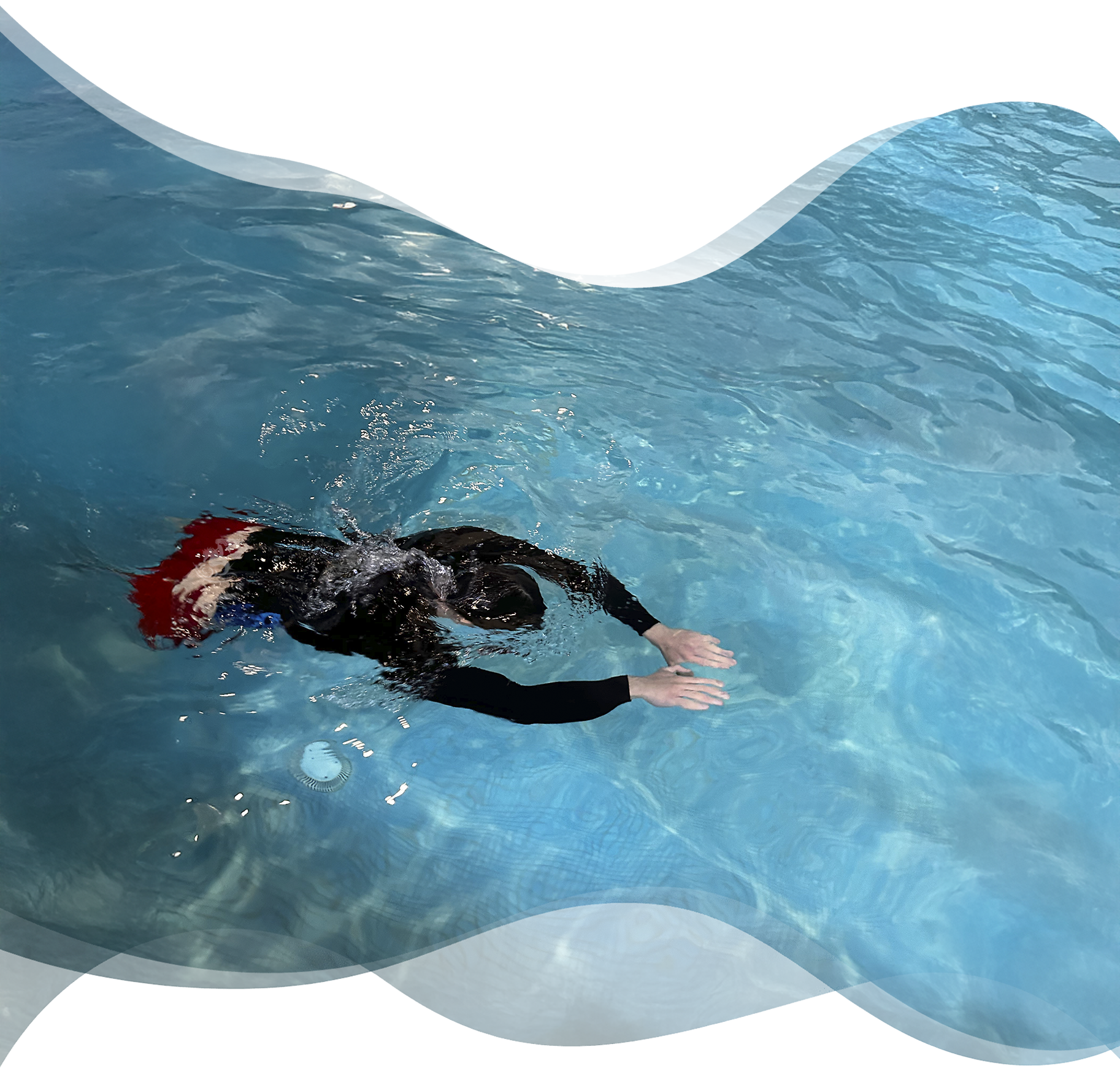 Adult swimmer holding streamline position underwater during private stroke correction session