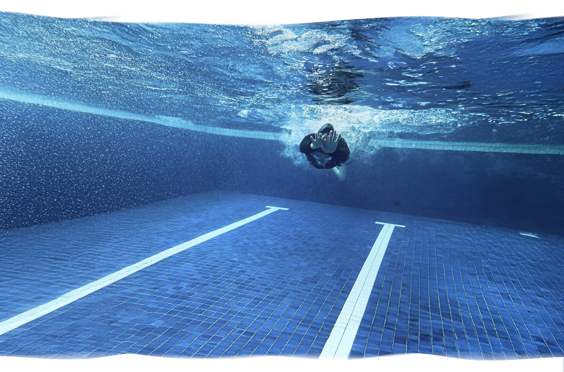 Underwater streamline by swimmer in lap pool during dive practice